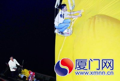 工人给大黄鸭系上绳子，准备起吊