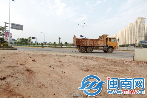 一辆渣土车开出工地，渣土一路掉