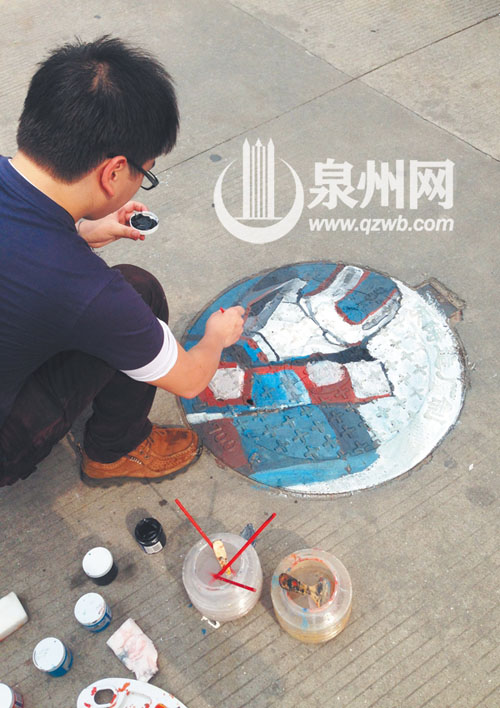华大男生在校园井盖上作画