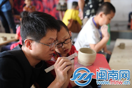 这对父子正在很用心地研究如何做陶杯
