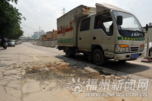 许多过往车辆均要避开这坑坑洼洼的道路