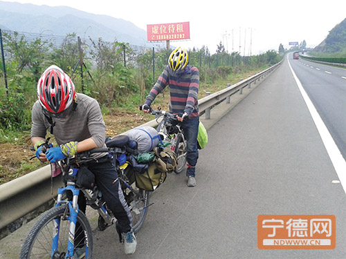 两名大学生在高速路上骑自行车。