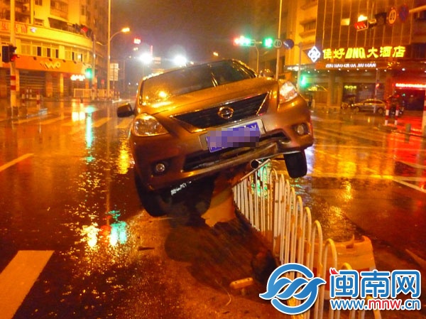肇事小车爬上路中央的护栏