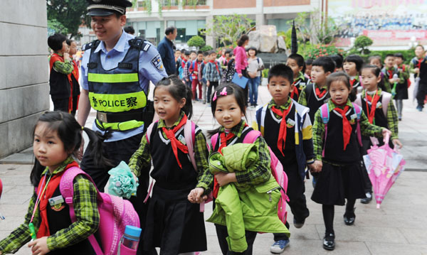 昨天中午放学，社区民警在鲤城区实验小学门口护送孩子