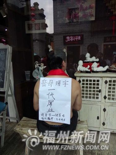 男子背对橱窗，许多游客围观