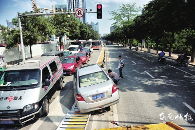 小车“骑”在护栏上，一整排护栏被撞倒