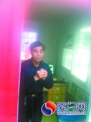 刘明高演示在保安亭内作揖的动作