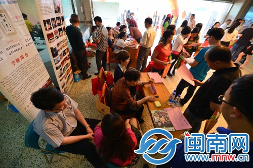 咨询会上，家长向学校招考老师咨询孩子的升学问题