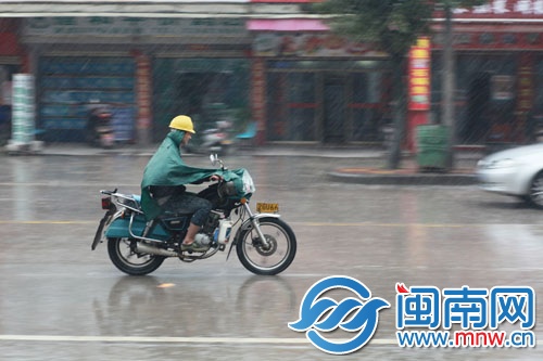 泉州浮桥街上，男子雨中奔波