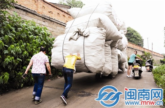 一位年轻人下车帮忙将板车推到平路