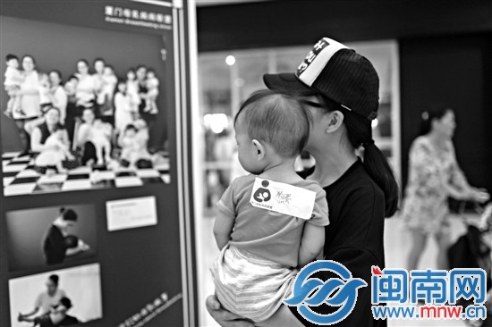 一位妈妈在观看哺乳摄影展图片