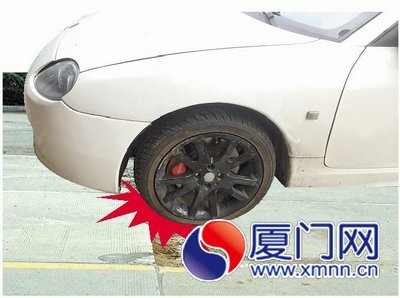 黄女士的跑车就是轧到这破损路面才爆胎的