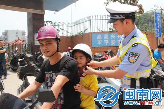 交警给小学生戴上安全头盔