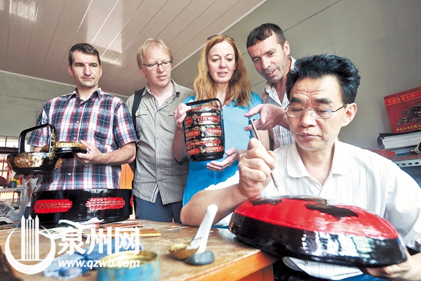 几个外国游客饶有兴致地观摩漆篮制作工艺