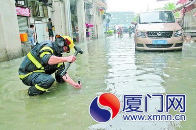 消防人员在磁安路的一处积水路段排水