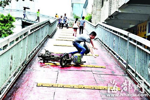 骑车下桥的男子不小心就滑倒了