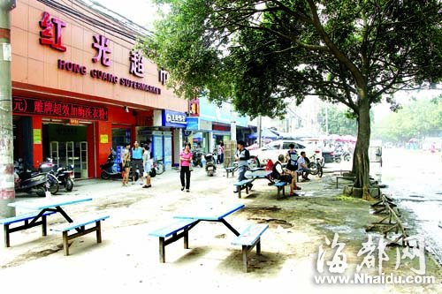 红光超市把桌椅摆在人行道上，行人通行多了不便