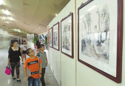 24日，市民在市体育馆欣赏郭东健画作