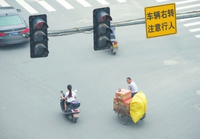 闯红灯、不戴头盔现象时有发生。本报记者陈明哲摄