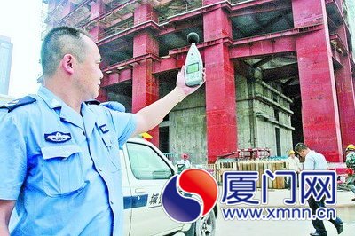 执法人员检测工地噪声。