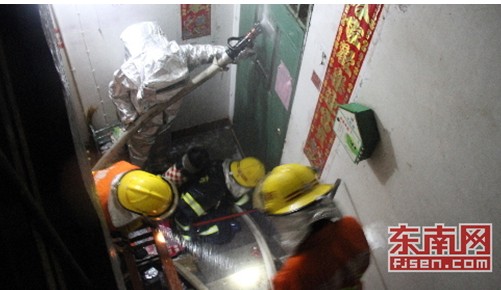 消防官兵利用撬棍和开门器对屋门进行破拆