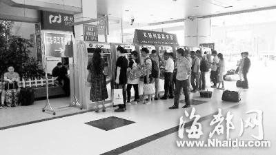 火车站取票机前，旅客正排队取票