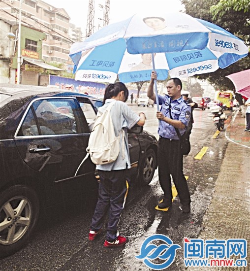 厦门一中考场外，一名民警帮考生撑伞