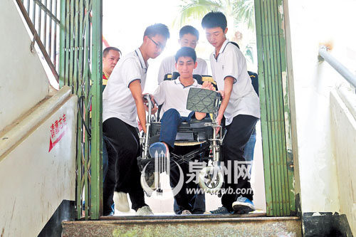 许同学坐在轮椅上，行动不便，三四个同学一起将他抬 