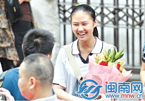 泉州五中，一名考生接过鲜花，露出灿烂的笑容