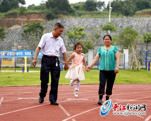 　在环境优美的新区，田仁志夫妇带着小女儿玩耍，说 