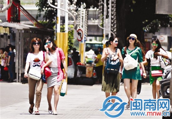 昨天天气晴好，阳光强烈，市区泉秀街上几位美女戴着 