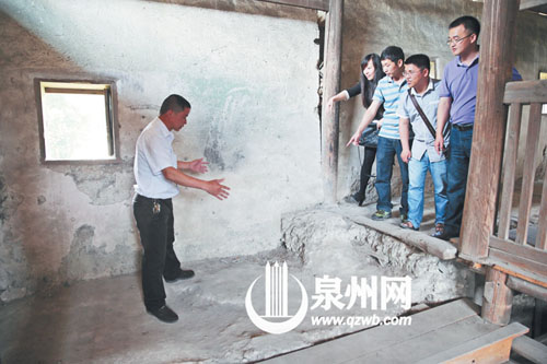 许进丁向游客们比划着土楼墙体的厚度，当年建造土楼 
