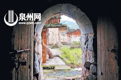 这一石拱门是土楼的边门，对面是土楼的配套古厝。