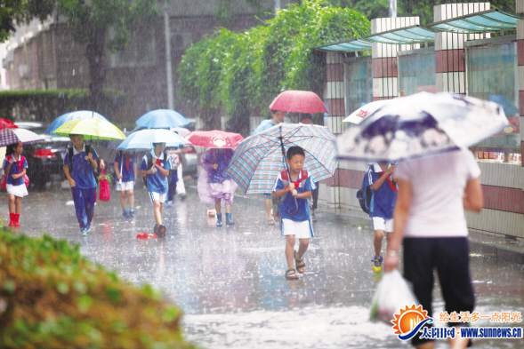 昨日早上，在金尚小学门口,孩子们冒雨上学。