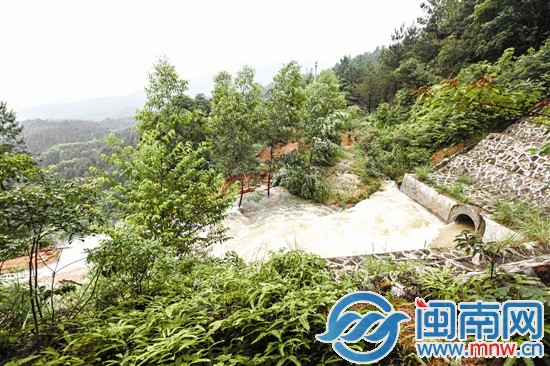 护坡塌方后，水流急速地从涵道口涌出