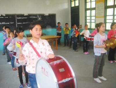 富泉民族中心小学的学生在乡村少年宫内练习鼓号演奏 