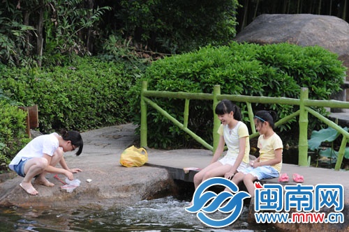天气太热，坐在水边玩水，让脚凉快些