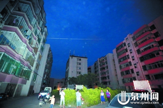 家里又黑又热，住户到楼下纳凉等电。