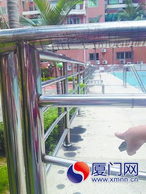 游泳池的栏杆和地上都是油污。