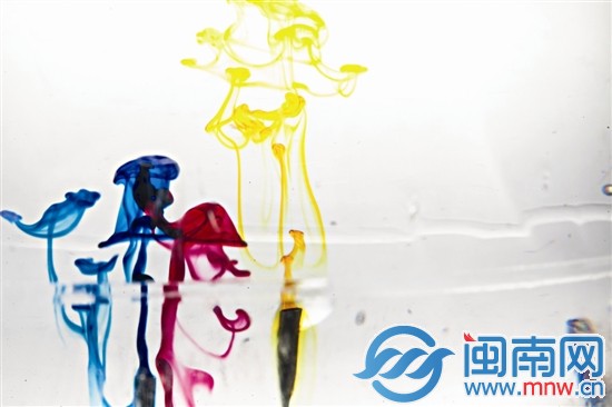 画笔刚接触水面，颜色在透明的水里散开，像是一只只 