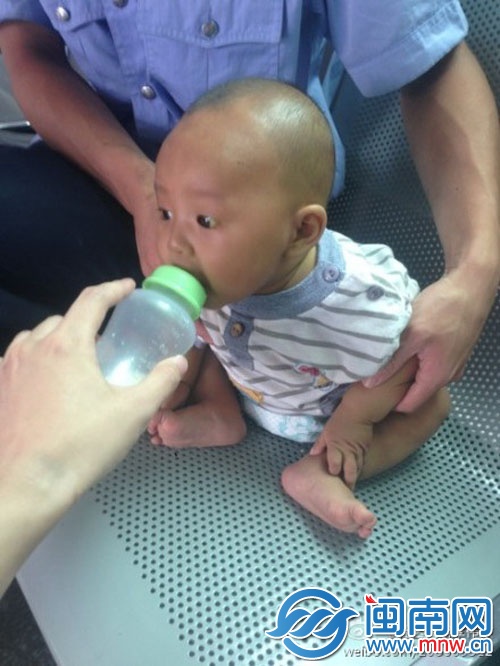 派出所内，民警在喂小孩喝奶粉
