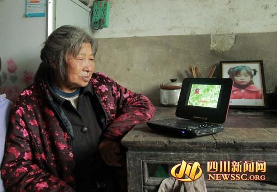 小微微的奶奶看着小微微的影像，忍不住老泪纵横