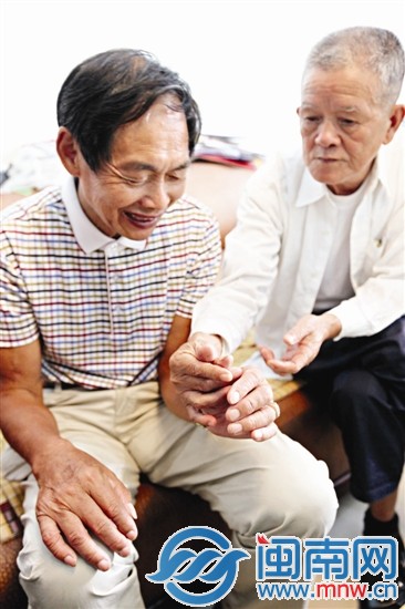 聊天时，钱阿伯（右）还跟蔡大伯比对掌纹
