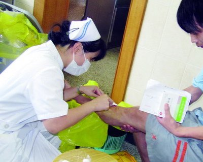 伤口治疗师蔡秋妮正在为患者处理伤口