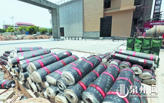 楼盘的空地上堆放着铺设沥青的材料