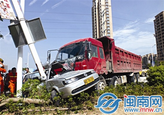 轿车被路灯杆与土方车死死卡住