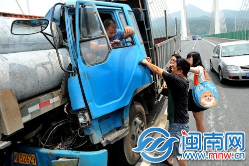 路过司机戚先生(前一)和记者将司机救下来