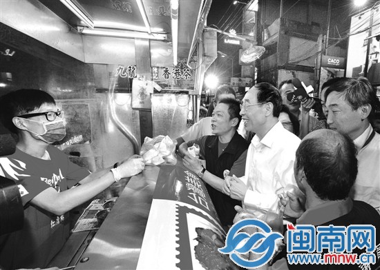 八日晚，省委书记尤权在台湾台中市逢甲夜市品尝当地 