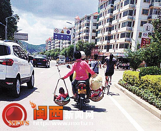 妇人悬空挑孩乘坐摩托车