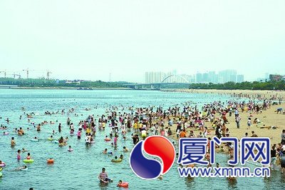 五缘湾天然浴场游客众多，有的游到了警戒线外